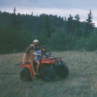 man and daughter riding atv